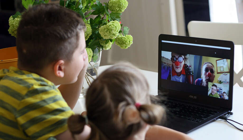 Két gyerek videótelefonáló bohócokat néz a laptopon