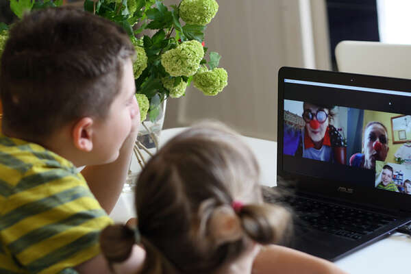 Két gyerek videótelefonáló bohócokat néz a laptopon