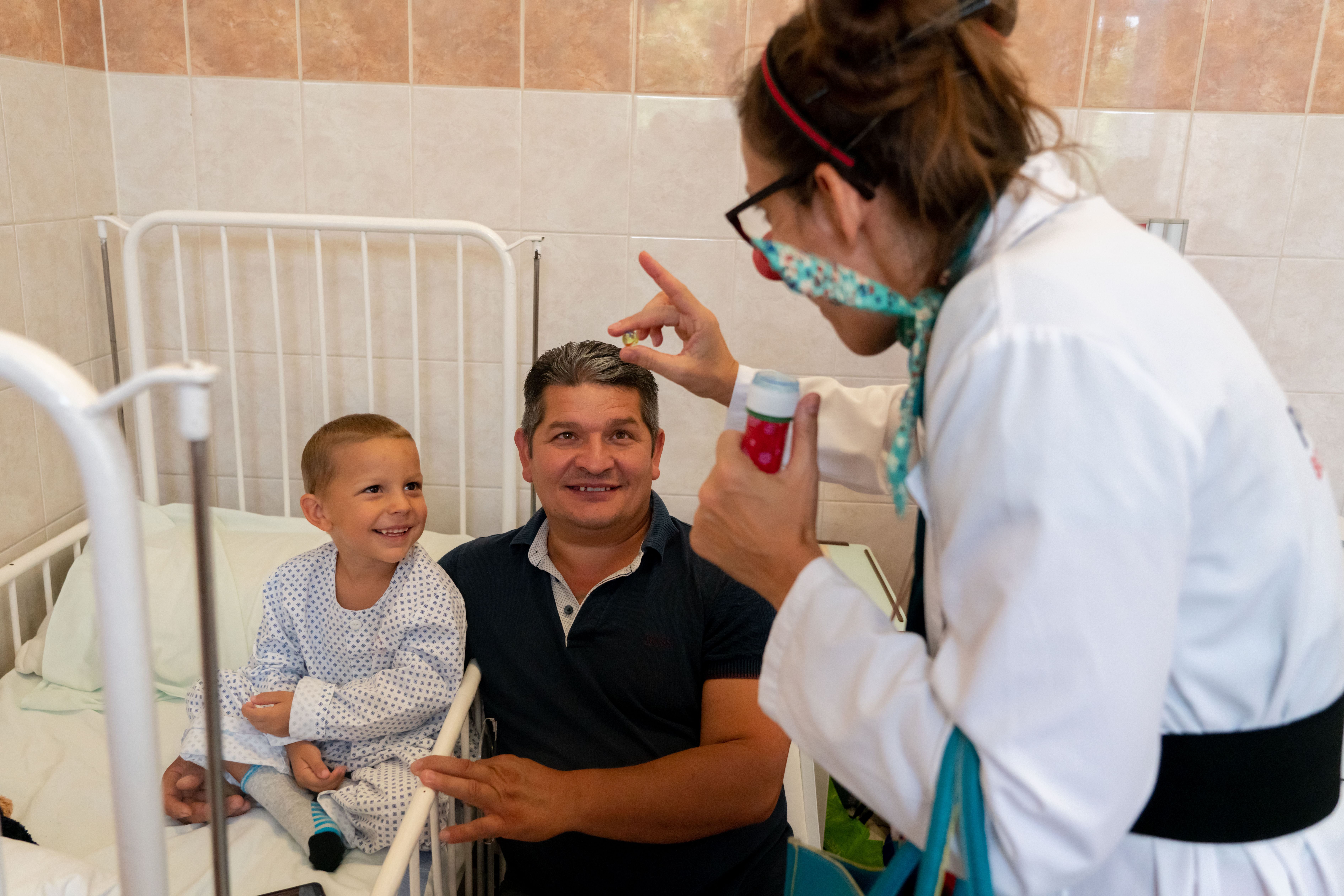 Gyermek és édesapja figyelik a bohócot